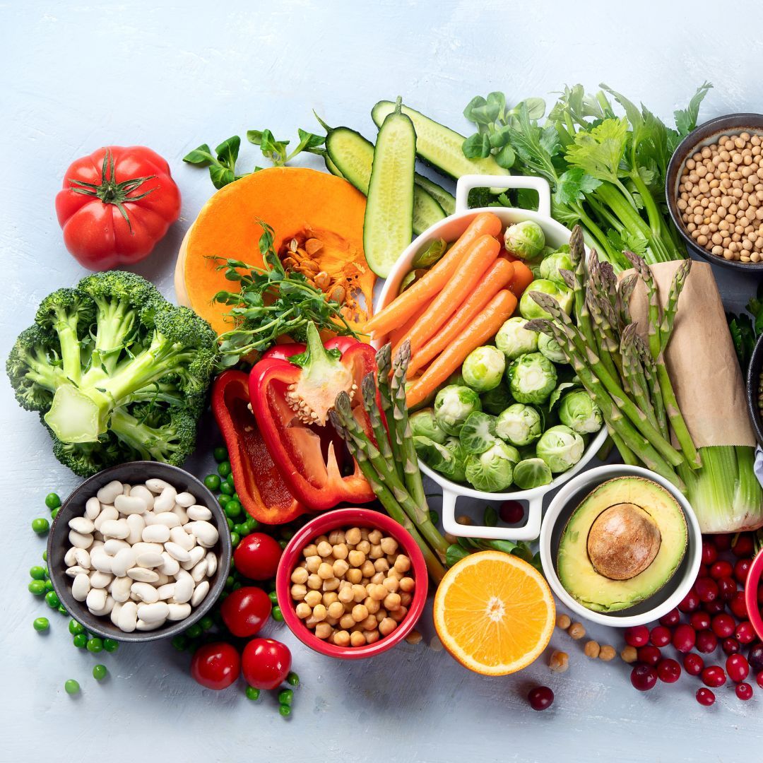 Flat lay of fresh vegetables, fruits, and legumes.