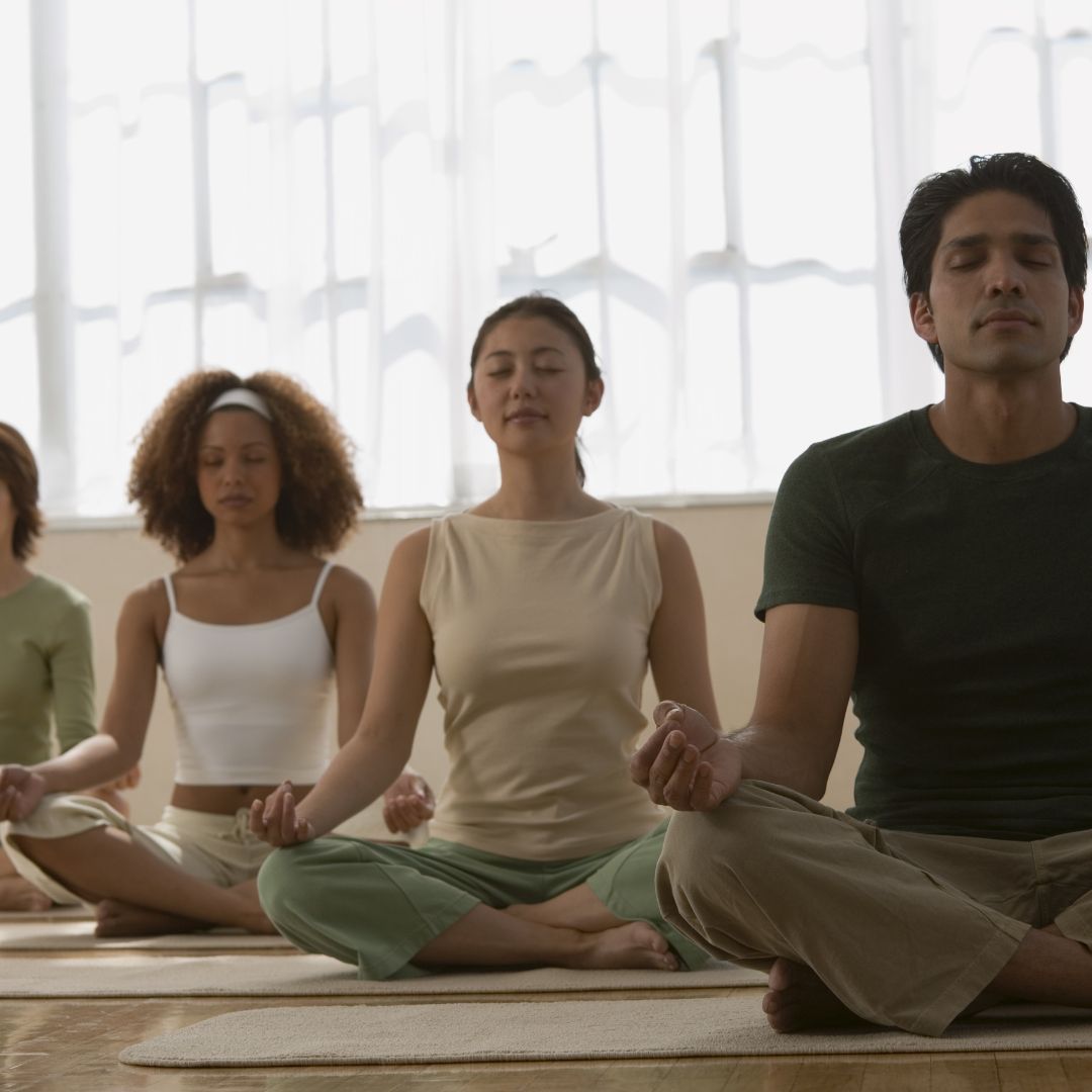 Group of people meditating in a yoga class.