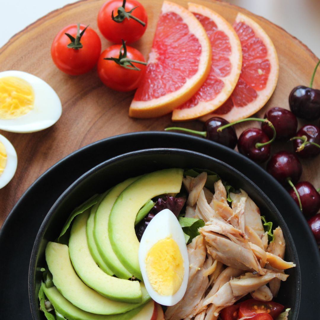 Healthy meal bowl with avocado, egg, and chicken.