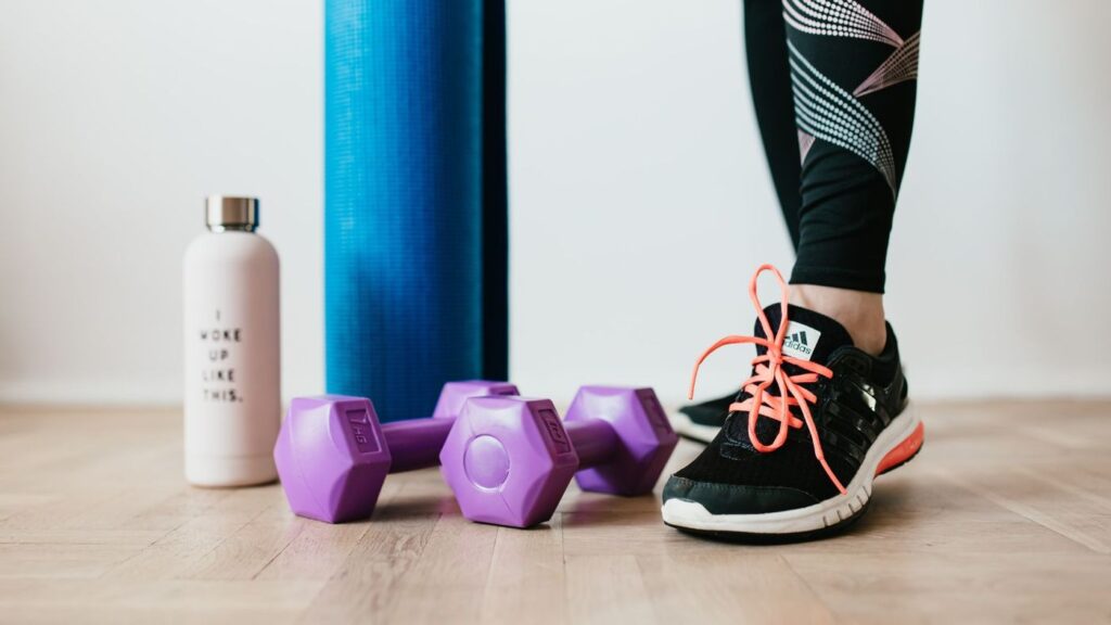 Workout gear including running shoes, dumbbells, and mat.