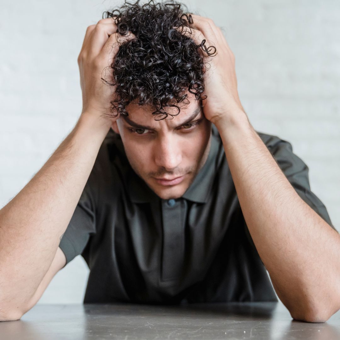 Stressed man holding his head in frustration.